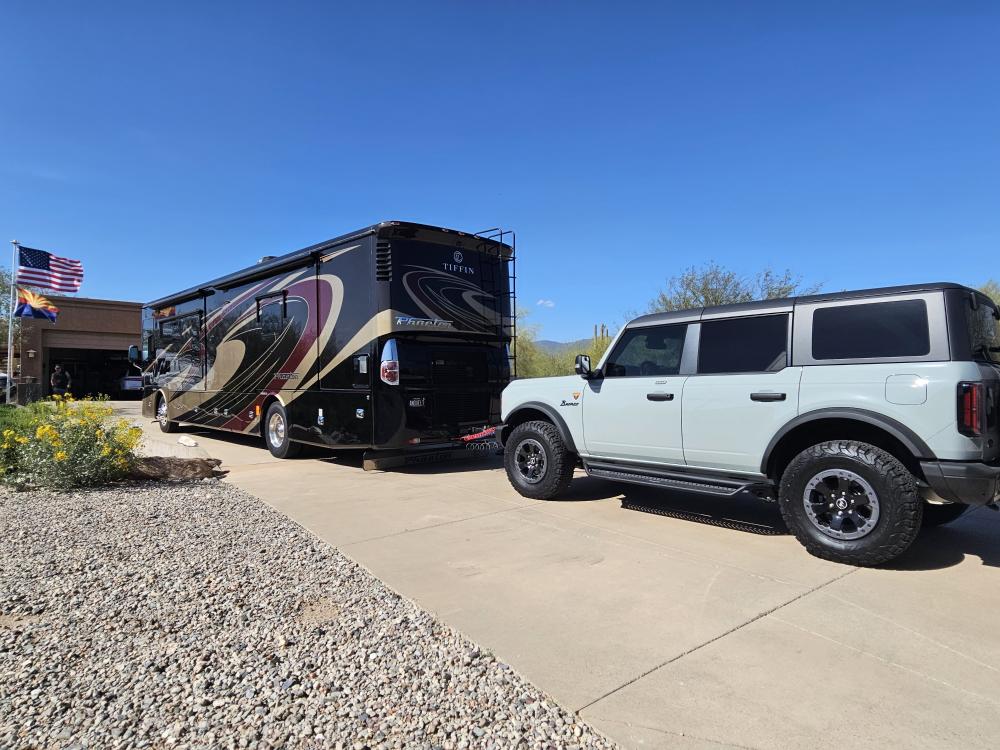 RV and SUV parked on a sunny driveway with a clear sky.