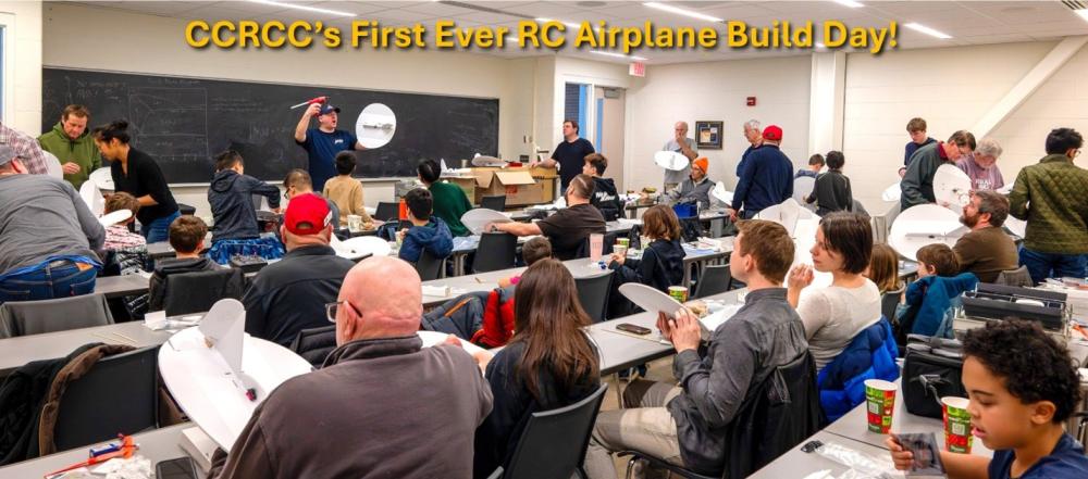 Crowded classroom with people building RC airplanes.