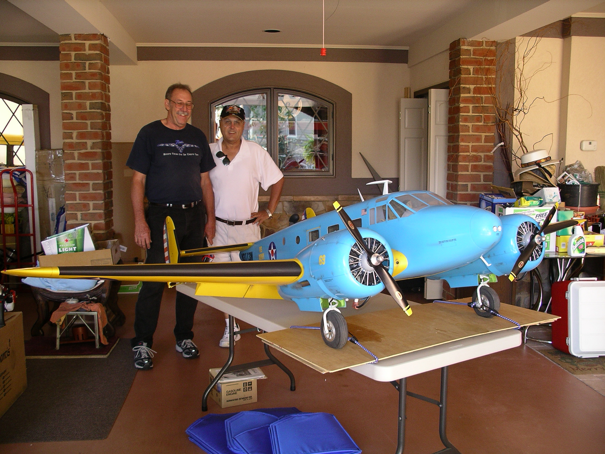 men behind a very large blue model airplane