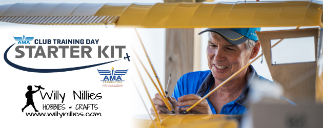 Man working on a large model airplane with focus and care.