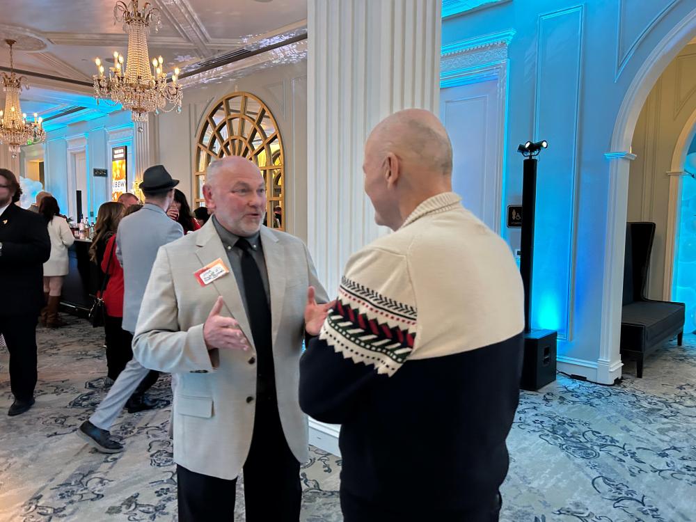 Two men in conversation at an elegant formal event.