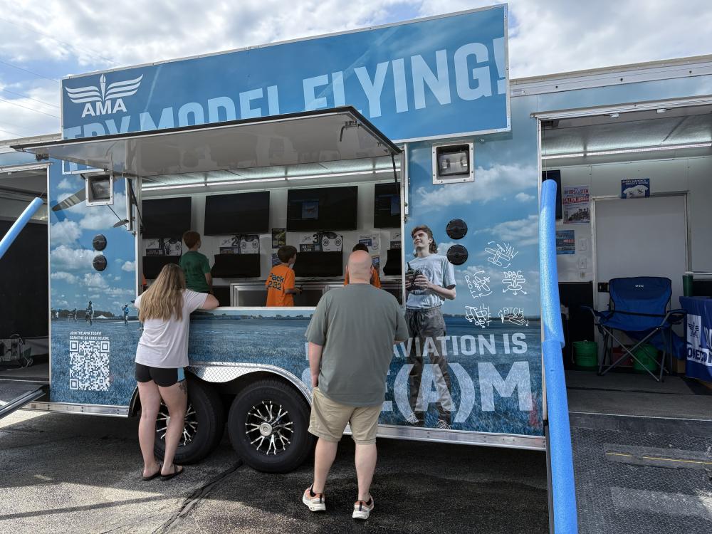 Model flying club trailer with people standing at the counter.