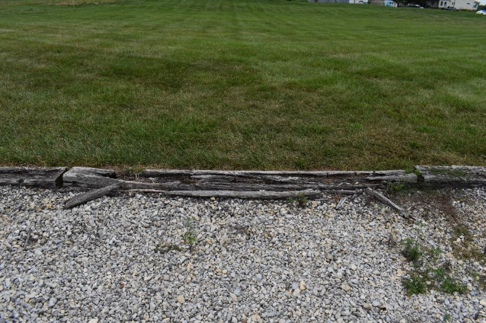 A gravel path between a grass fieldAI-generated content may be incorrect.