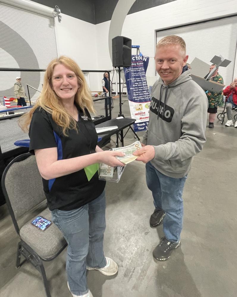Two people exchanging cash at an indoor event.