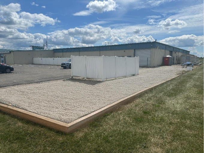 A building with a lot of grass and a parking lotAI-generated content may be incorrect.