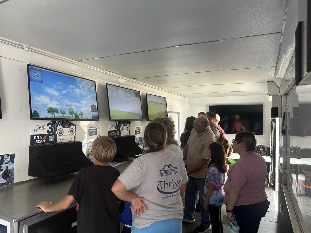 People gathered in a room with screens displaying nature scenes.
