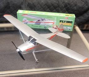 Model airplane with silver body and red accents on a glass table.