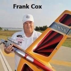Man holding a model airplane with a yellow and red design outdoors.
