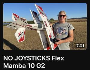 Man smiling, holding a large radio-controlled airplane outdoors.