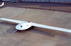 Drone on a tarmac, long wings and sleek body, viewed from above.