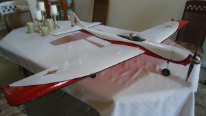 Model airplane with red and white wings on a table.