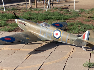 Model warplane on a tiled patio, painted in green and brown camo.