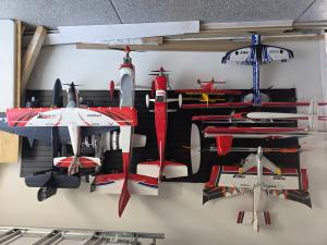 Radio-controlled planes displayed on a garage wall.