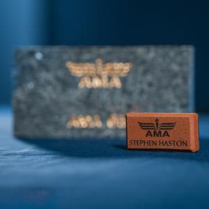 Brown and black AMA plaques on a blue surface.