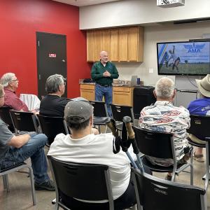 Man giving a presentation to seated people in a classroom.