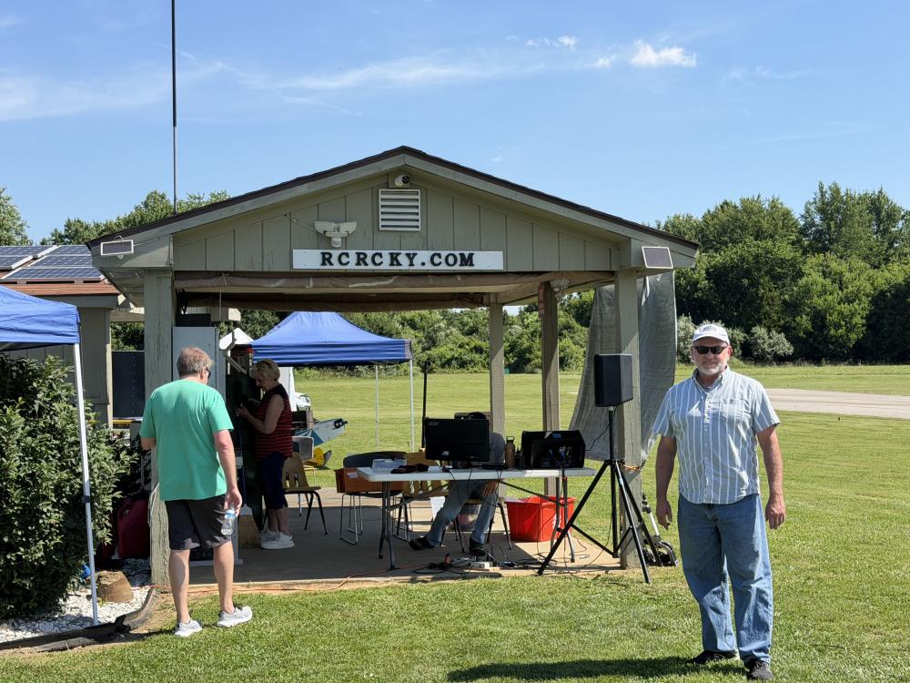 Small outdoor pavilion with people under a sunny sky.